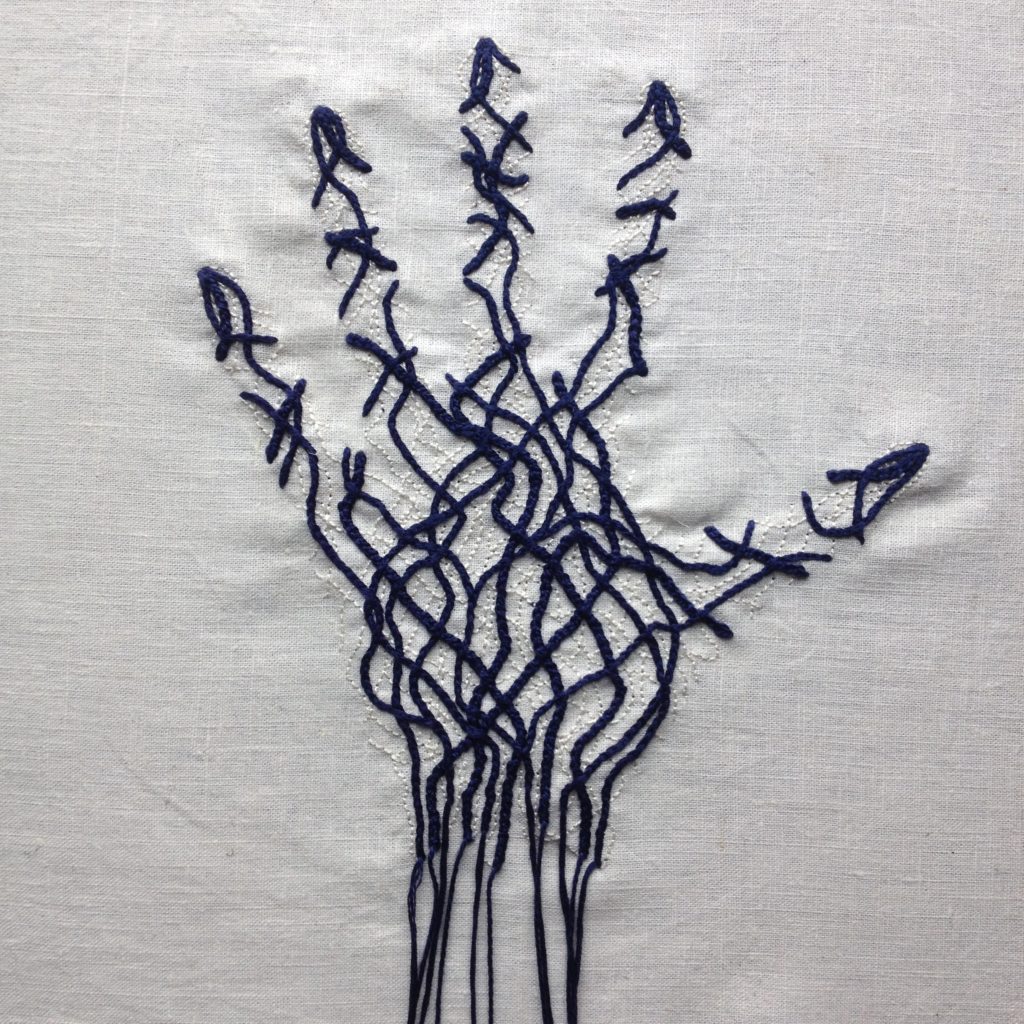 An embroidery on bone white linen. There is the faint outline of a hand, fingers apart. The hand is filled with thick dark blue lines intertwining and crossing over. There are finer thin lines in bone white beneath the thick blue lines. At the wrist, the thick blue lines end in strands of thick thread, hanging over the edge of the linen.
