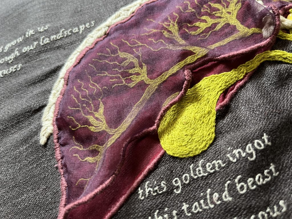 A red & purple organza liver on grey linen. The biliary system between the 2 layers is bilious green. A close up of the pear-shaped gallbladder with viscous-looking fine stitching. The text below it reads: This golden ingot.