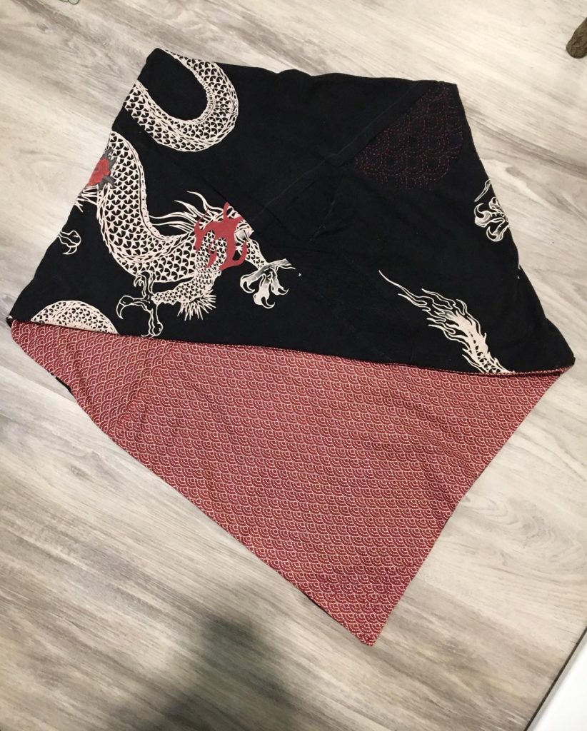 The same shawl from the back. There is some red sashiko stitching in a half circle shaped section on the upper right of the shawl.