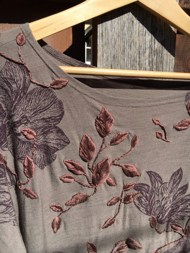 A close up of the previous dress showing detail of the leaves and vines embroidered on it.