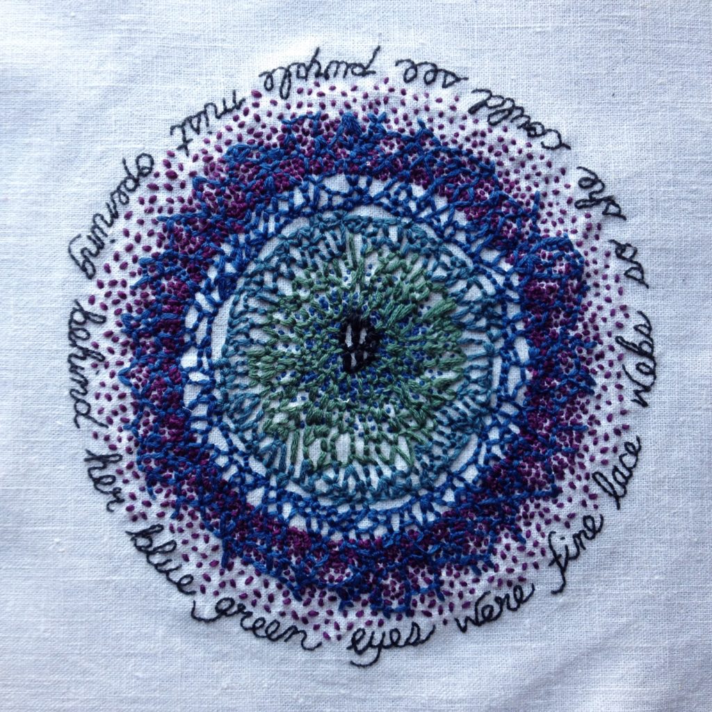 An embroidery of the venations of the eye stitched in blues, greens, and purples on bone coloured cloth. In a circle outlining the eye is a poem that can be read starting on any word: behind her blue green eyes were fine lace webs so she could see purple mist opening. 